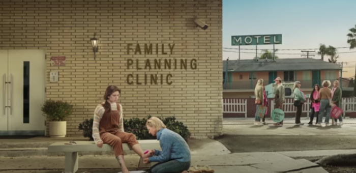An ad from the 'He Gets Us' campaign titled 'Foot Washing,' which aired during Super Bowl LVIII, includes an image of an older woman washing the feet of a younger woman outside an abortion clinic.